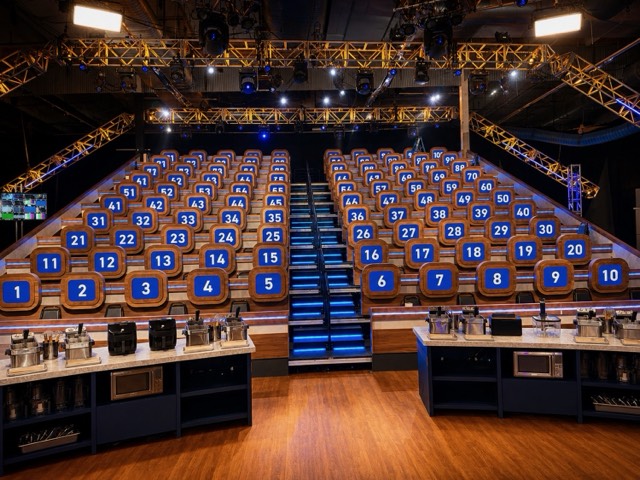 Game show set with numbered audience stations and lighting truss.